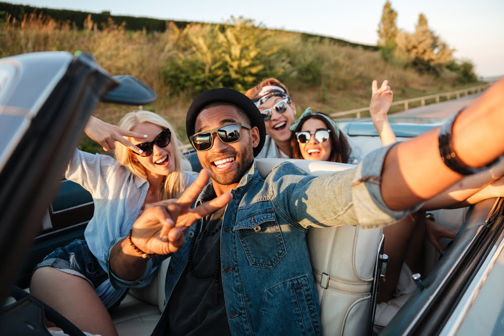 A group of friends exploring Indiana wineries in a convertible car.